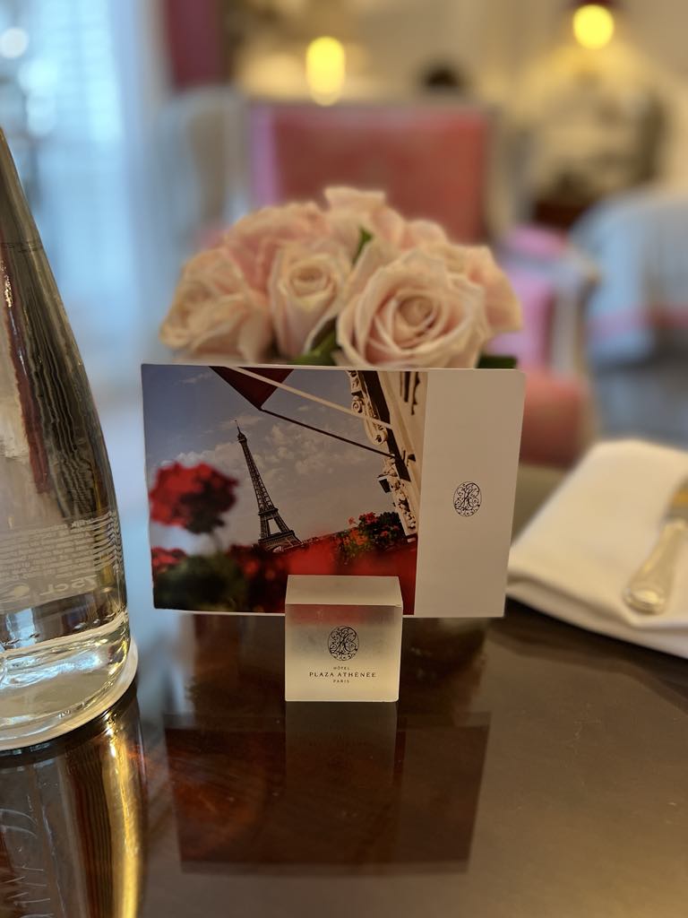 Elegant welcome arrangement featuring fresh roses and a personalized note left in-room at a luxury hotel, creating a warm and thoughtful arrival experience for guests.