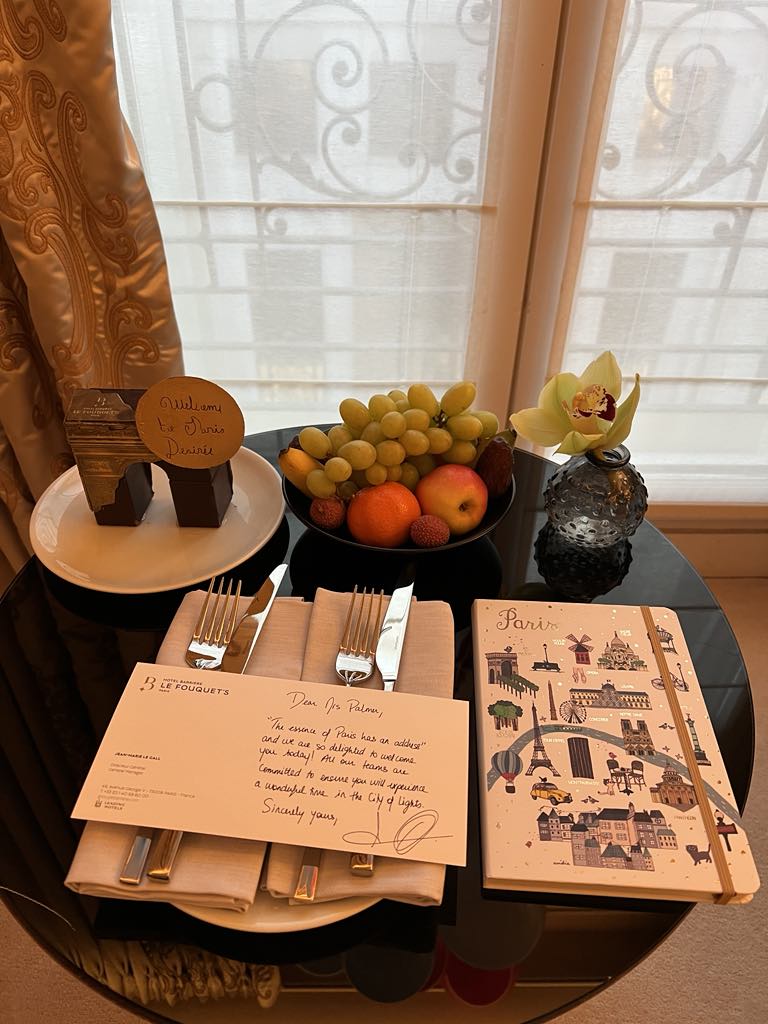 Charming in-room welcome treat featuring French pastries and a Paris guidebook at a luxury hotel, offering a warm and personalized arrival experience for guests exploring the City of Light.