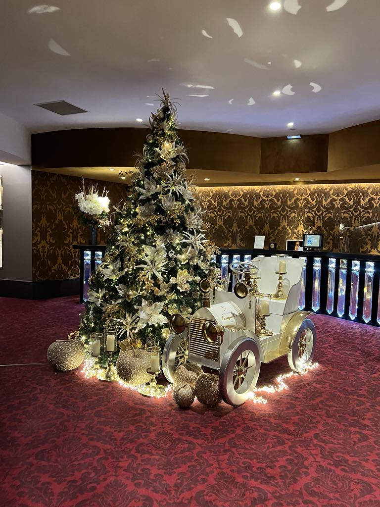 Elegant hotel lobby adorned with Christmas decorations, including a grand tree, twinkling lights, and seasonal accents—creating a warm and festive atmosphere for holiday guests.