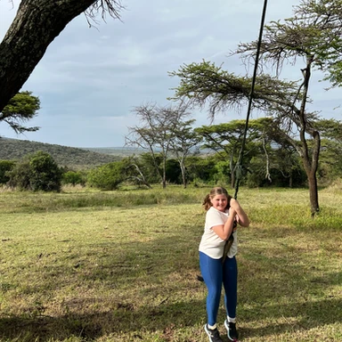 Teen traveler enjoying a rope swing at Cottar’s 1920s Camp in Kenya, experiencing luxury safari life and outdoor fun in the African wilderness.