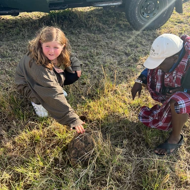 Teen traveler spotting a turtle in the wild with safari guide Mako at Cottar’s 1920s Camp in Kenya, enjoying hands-on wildlife exploration during a luxury family safari.