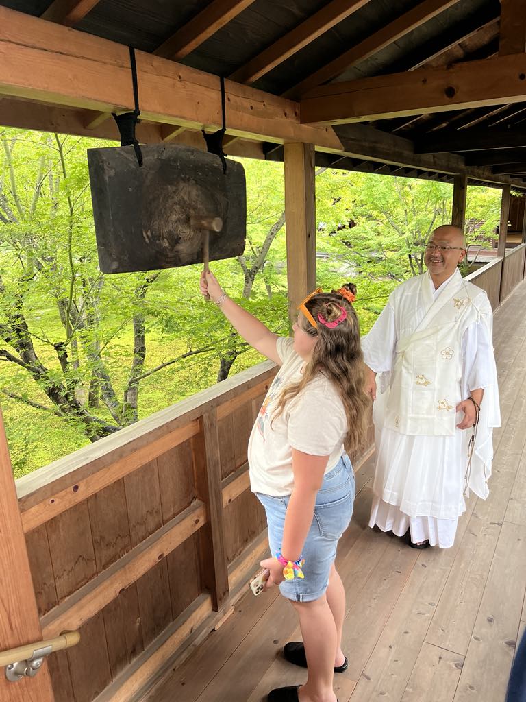 Teen traveler Harper meeting a real-life Buddhist monk during a cultural and spiritual encounter in Japan, gaining insight into local traditions on a family journey.