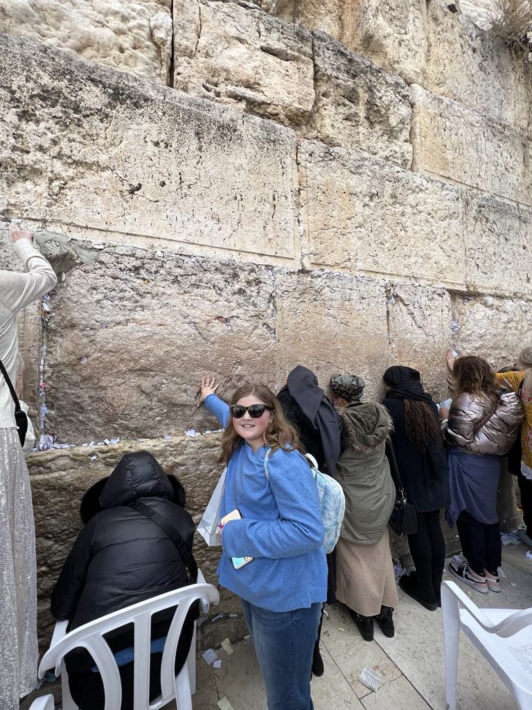 Teen Girl harper touching the western wall in Jerusalem Israel