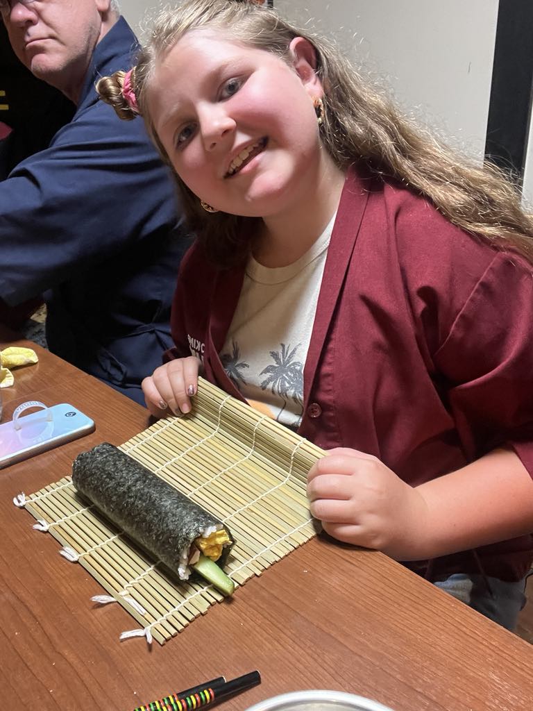 Teen traveler Harper learning to make authentic Japanese cuisine during a hands-on cooking class in Kyoto, embracing cultural immersion as part of her luxury family adventure in Japan.