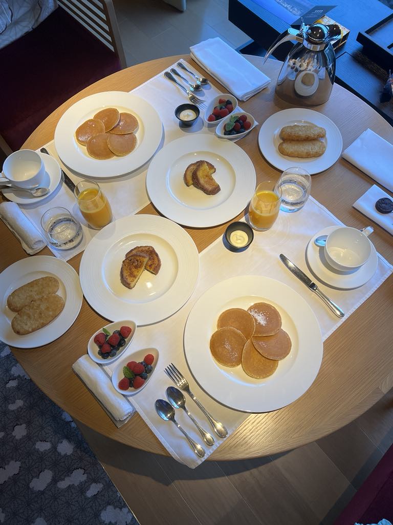 Elegant room service meal featuring gourmet dishes, beautifully presented in a luxury hotel setting during a family stay.