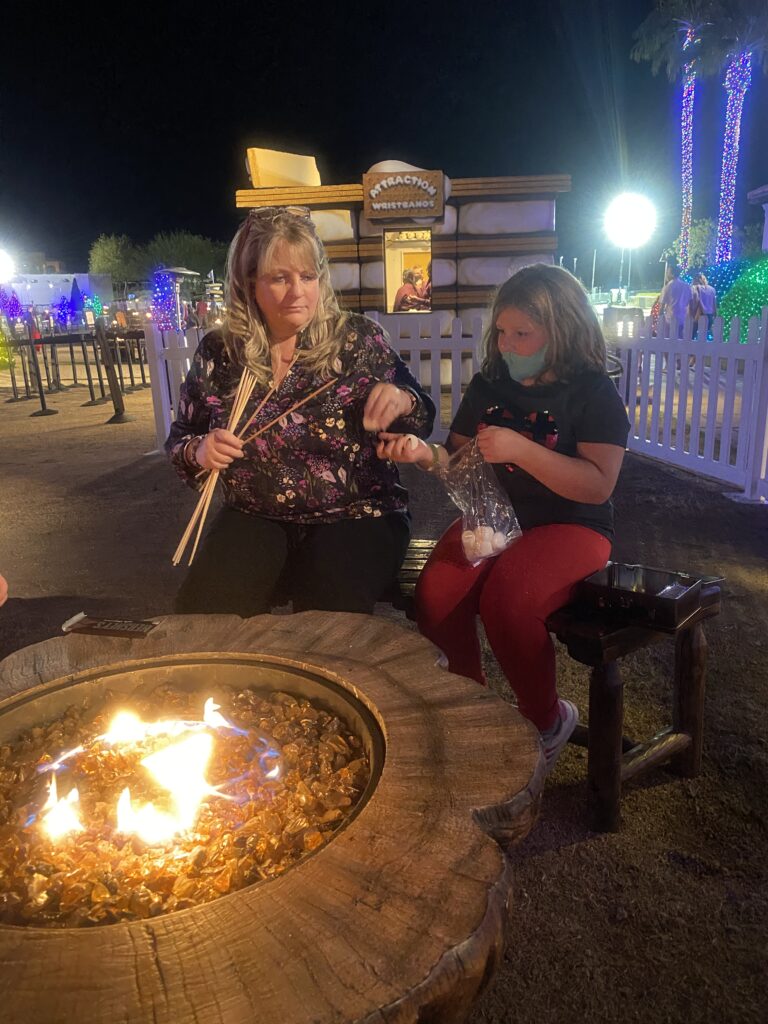 Family-friendly s’mores making experience at the Fairmont Scottsdale Princess, with guests roasting marshmallows over glowing fire pits during the “Christmas at the Princess” holiday celebration.