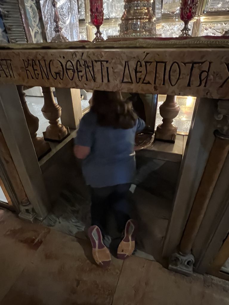 Teen girl Harper touching the stone where Jesus died