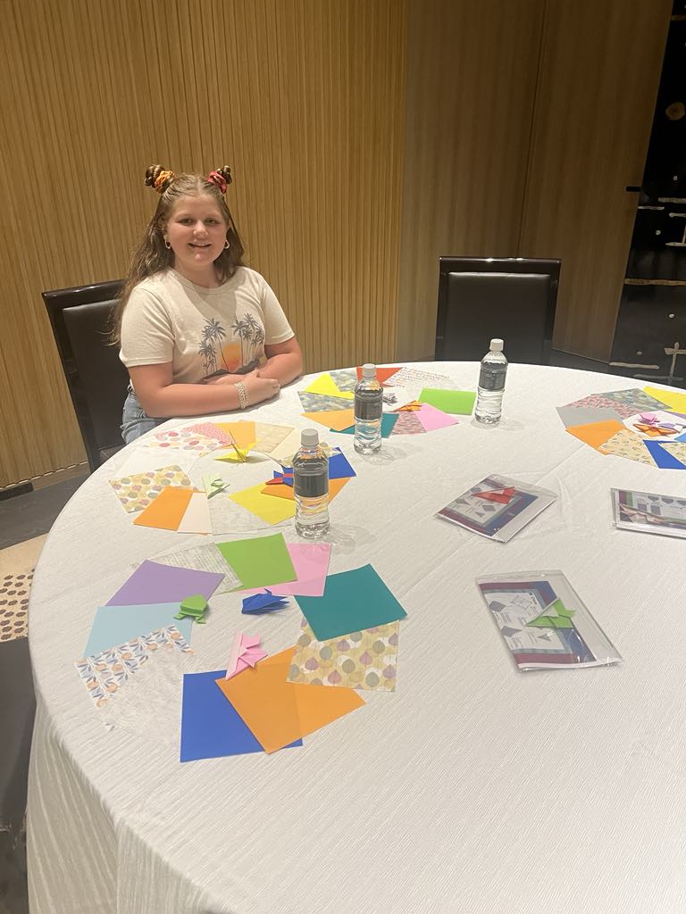 Teen traveler Harper creating traditional Japanese origami, engaging in hands-on cultural learning during a luxury family trip to Kyoto.