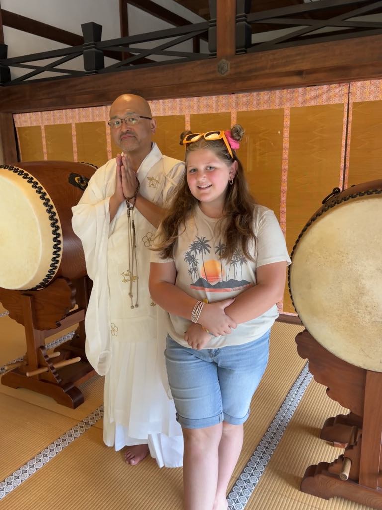 Teen traveler Harper meeting a real-life Buddhist monk during a cultural and spiritual encounter in Japan, gaining insight into local traditions on a family journey.
