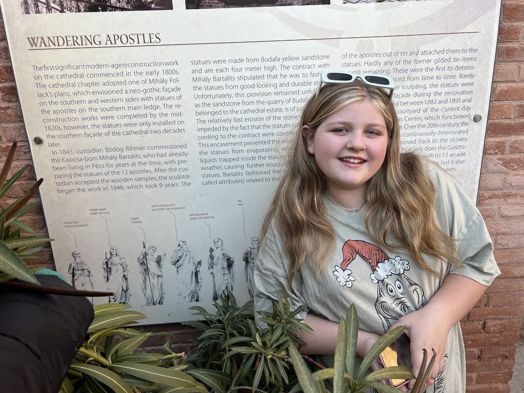 Teen girl Harper in front of Wandering Apostles sign