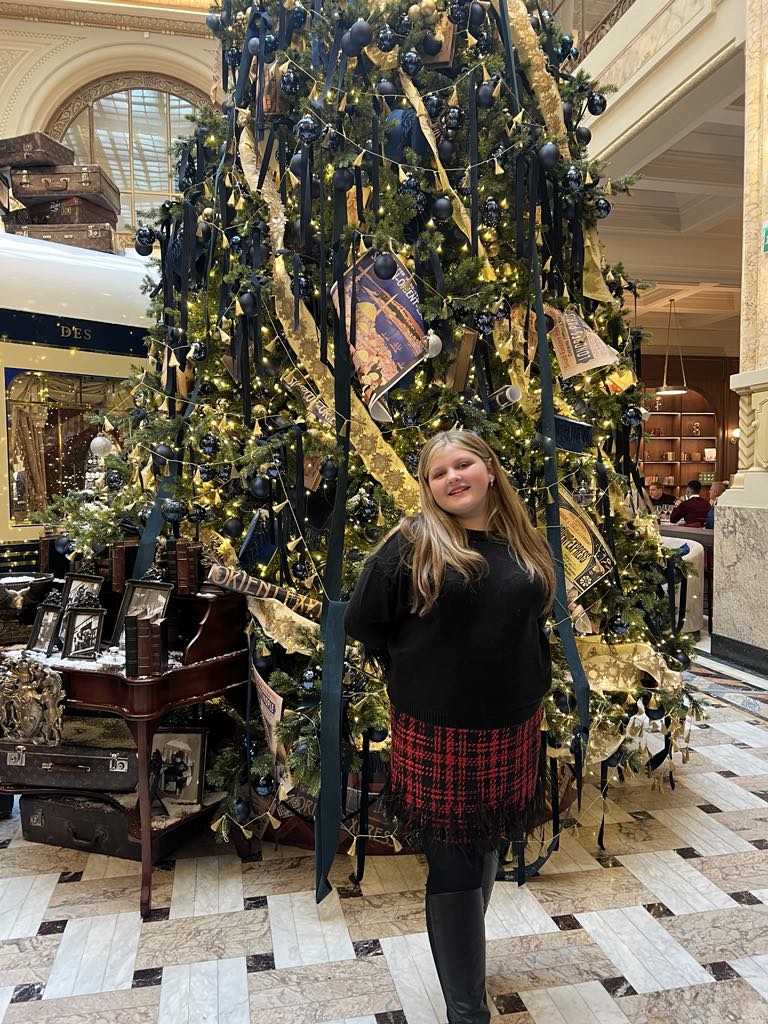 Teen girl Harper standing in from of holiday tree at marmorosch hotel, bucharest romania
