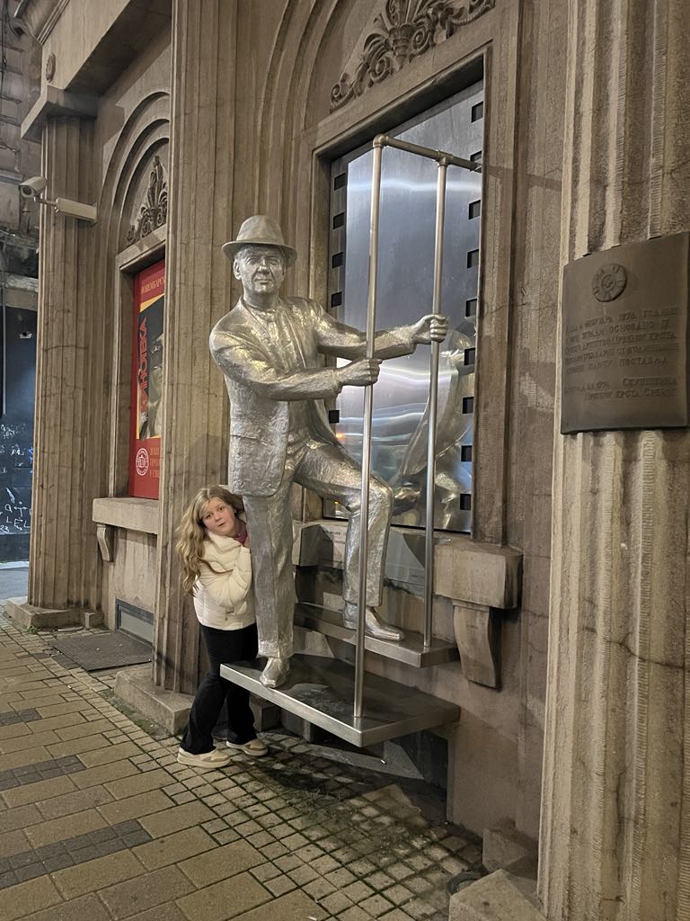 Teen girl Harper in Theater district of Belgrade Serbia behind Karl Malden