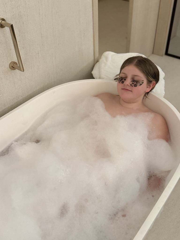 Harper lounging in bath tub with bubble at Hotel Arts in Barcelona, Spain
